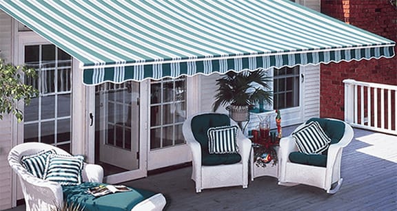 Porch with nice awning overhanging it that matches the green striped chairs under it
