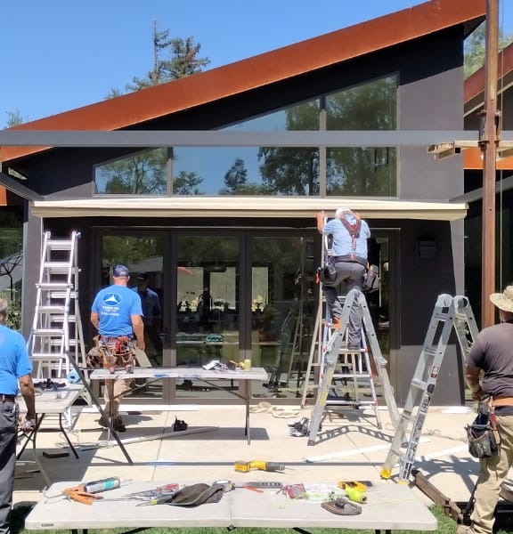 Goodwin-Cole team installing a pergola structure over an outdoor patio